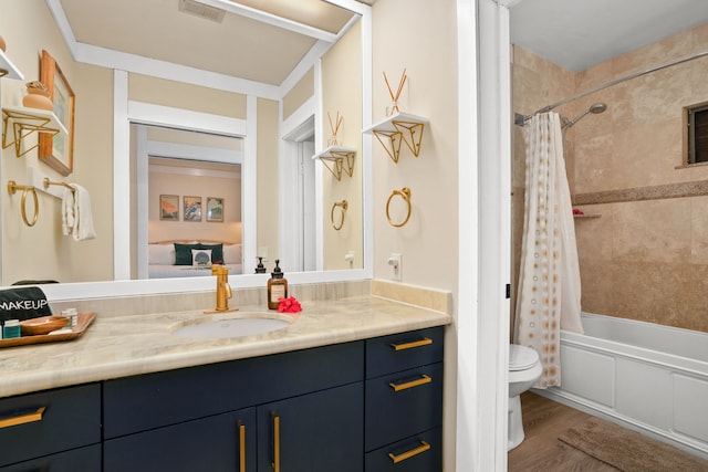 full bathroom with hardwood / wood-style floors, vanity, shower / tub combo with curtain, and toilet