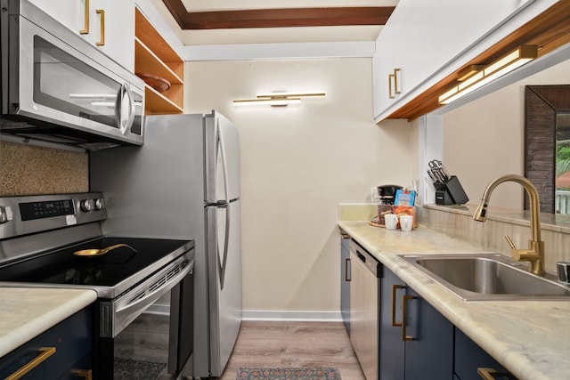 kitchen featuring blue cabinets, sink, appliances with stainless steel finishes, and light hardwood / wood-style flooring