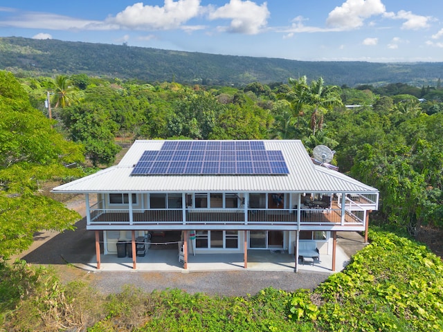 back of house with a patio and solar panels