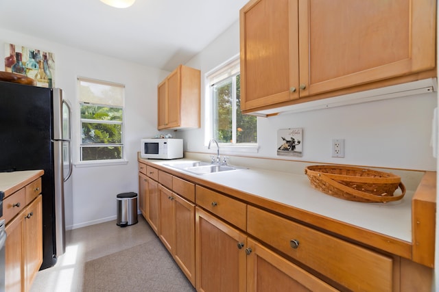 kitchen featuring stainless steel refrigerator and sink