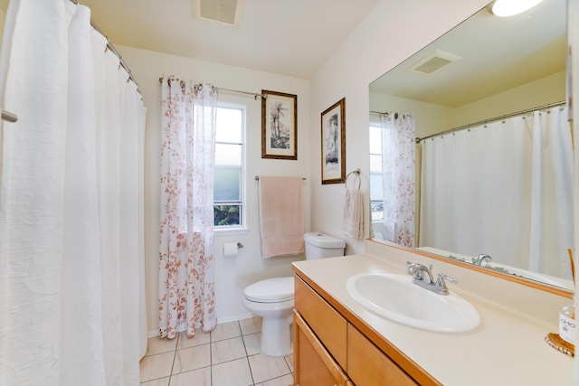 bathroom featuring vanity, tile patterned flooring, plenty of natural light, and toilet