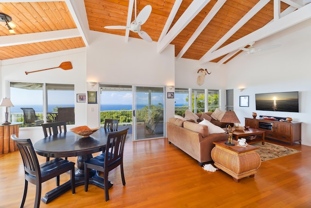 living room with beamed ceiling, wooden ceiling, ceiling fan, and light hardwood / wood-style floors