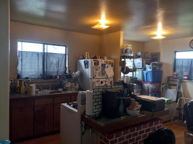 kitchen featuring white refrigerator, dark hardwood / wood-style flooring, sink, and a textured ceiling