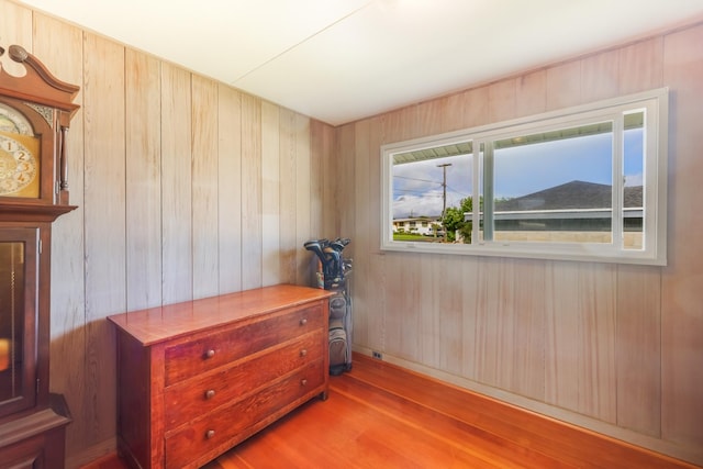 bedroom featuring wooden walls and light hardwood / wood-style floors