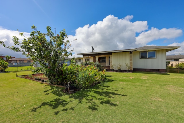 rear view of property with a lawn