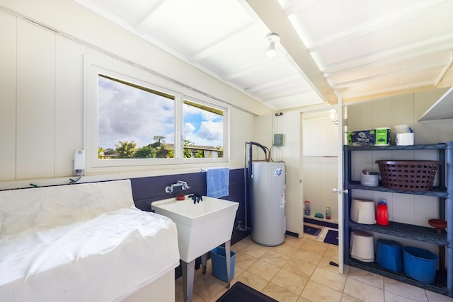 washroom featuring electric water heater, sink, and light tile patterned floors