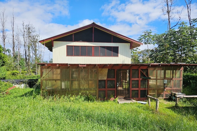 rear view of house featuring an outdoor structure