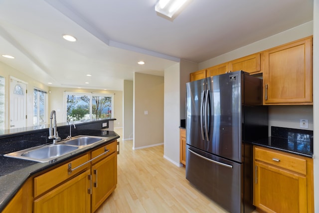 kitchen featuring light wood-type flooring, sink, and stainless steel refrigerator