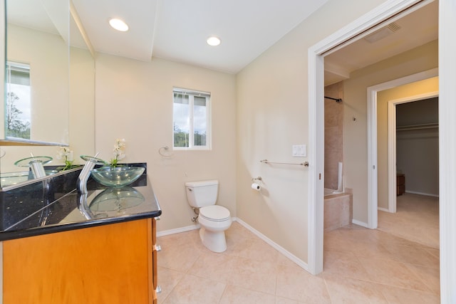 full bathroom featuring tile patterned flooring, vanity, toilet, and tiled shower / bath combo