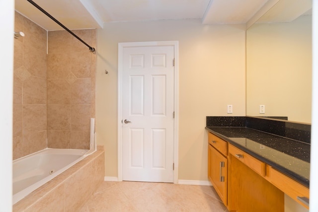 bathroom with tile patterned flooring, vanity, and tiled shower / bath