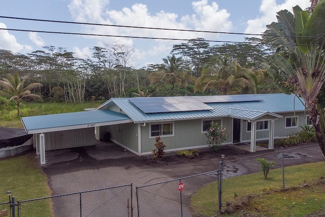 view of front facade featuring solar panels and a carport