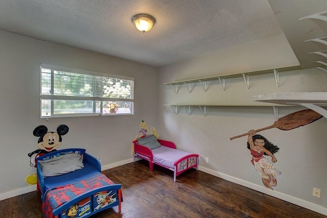 bedroom with a textured ceiling and dark hardwood / wood-style floors