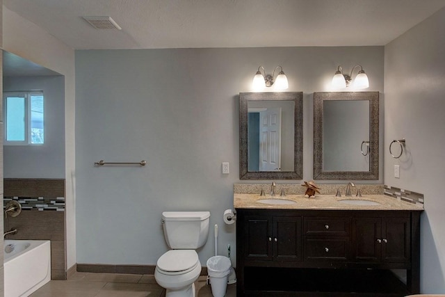 bathroom featuring tile patterned floors, vanity, toilet, and a tub