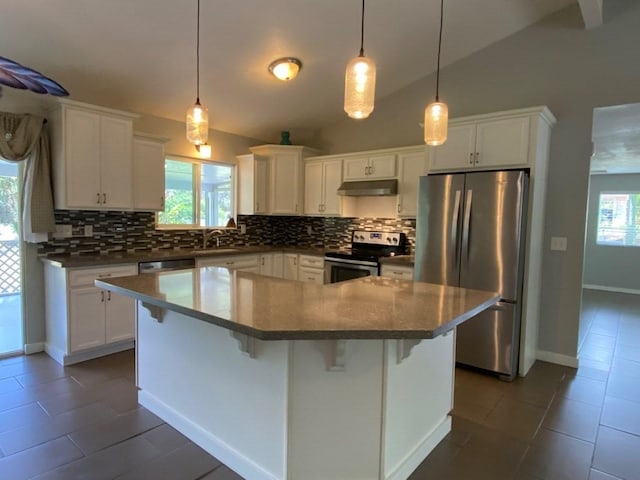 kitchen with white cabinets, appliances with stainless steel finishes, and lofted ceiling