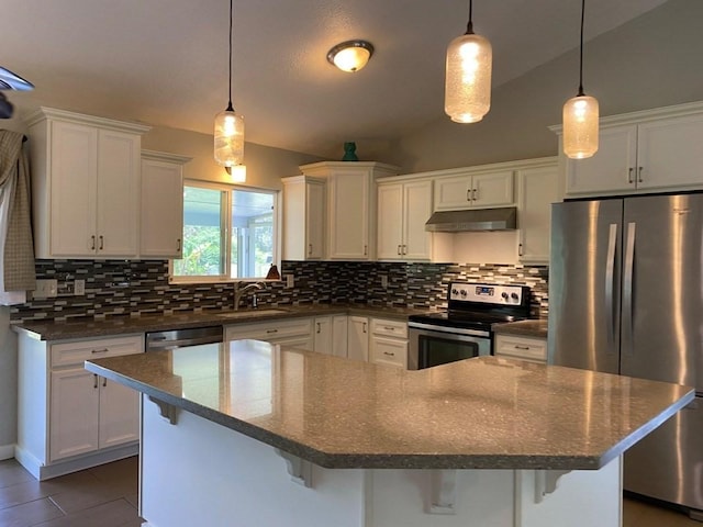 kitchen with lofted ceiling, a kitchen breakfast bar, hanging light fixtures, sink, and appliances with stainless steel finishes