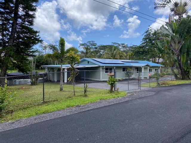 view of front of house featuring a front yard and solar panels