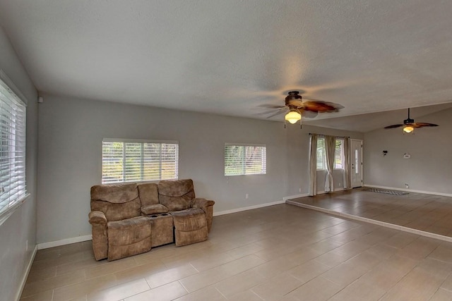 living room featuring ceiling fan and a textured ceiling