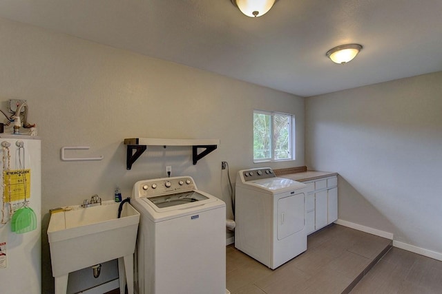 washroom with water heater, sink, cabinets, and independent washer and dryer