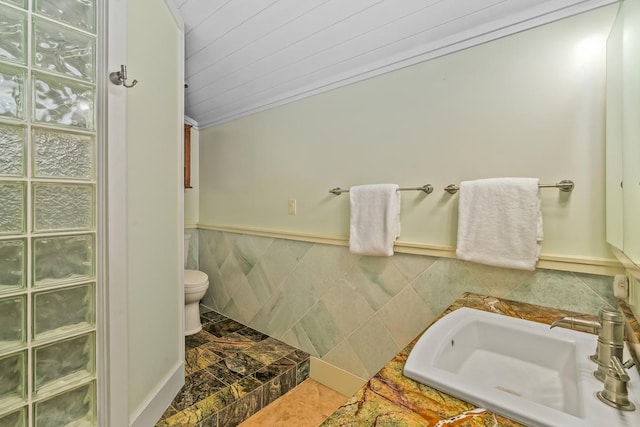 bathroom featuring sink, tile walls, and ornamental molding