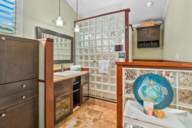 bathroom with a shower, vanity, and ornamental molding