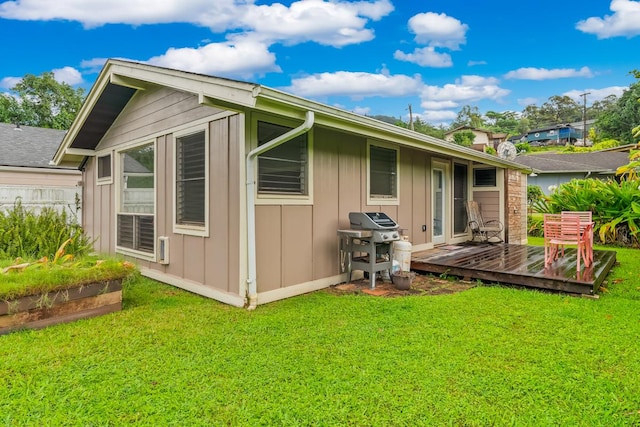 rear view of property with a deck and a lawn