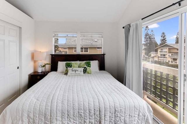 bedroom with vaulted ceiling and multiple windows