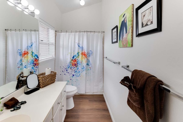 bathroom featuring hardwood / wood-style floors, lofted ceiling, toilet, vanity, and a shower with shower curtain