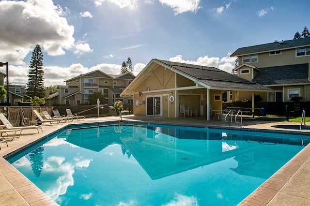 view of pool featuring a patio area, an in ground hot tub, and an outdoor structure