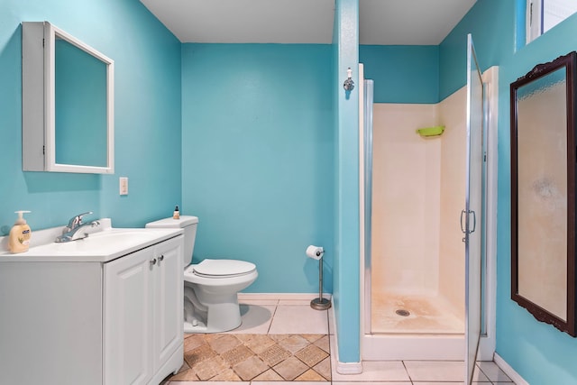 bathroom with tile patterned flooring, vanity, toilet, and a shower with door