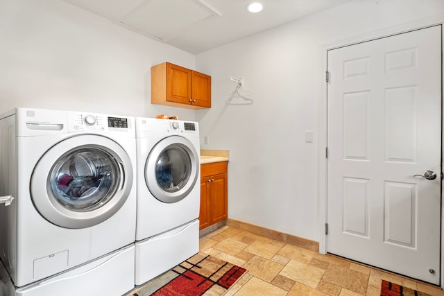 laundry area featuring washing machine and clothes dryer and cabinets