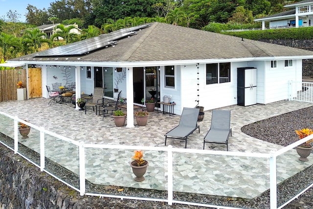 back of property featuring solar panels and a patio