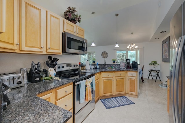 kitchen featuring light brown cabinets, dark stone counters, hanging light fixtures, a notable chandelier, and stainless steel appliances