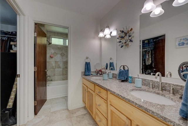 bathroom with tile patterned flooring, vanity, and tiled shower / bath combo