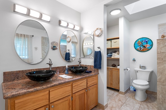 bathroom with vanity, toilet, and a skylight