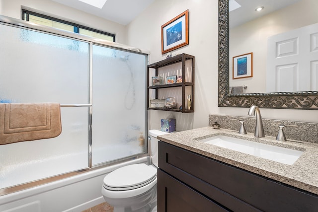 full bathroom featuring vanity, bath / shower combo with glass door, and toilet