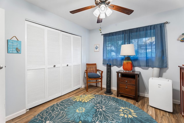 living area featuring hardwood / wood-style floors and ceiling fan