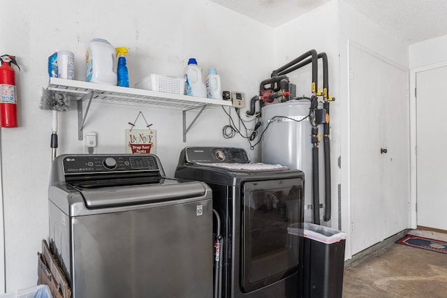 laundry area featuring gas water heater, a textured ceiling, and washing machine and clothes dryer