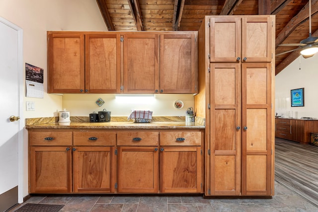 kitchen featuring lofted ceiling with beams, ceiling fan, and wooden ceiling