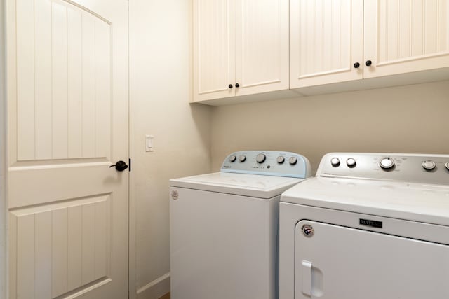 clothes washing area featuring cabinets and independent washer and dryer