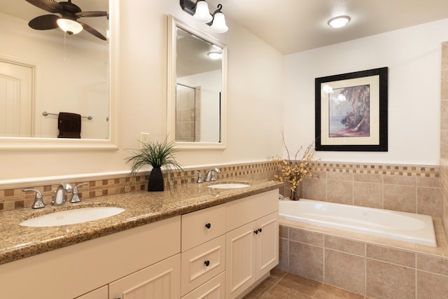 bathroom featuring tile patterned floors, tiled bath, ceiling fan, and vanity