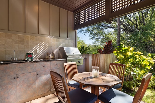 view of patio / terrace with area for grilling, a grill, and sink