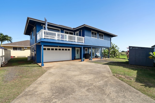 view of front of house with a garage, a front yard, a balcony, and central air condition unit