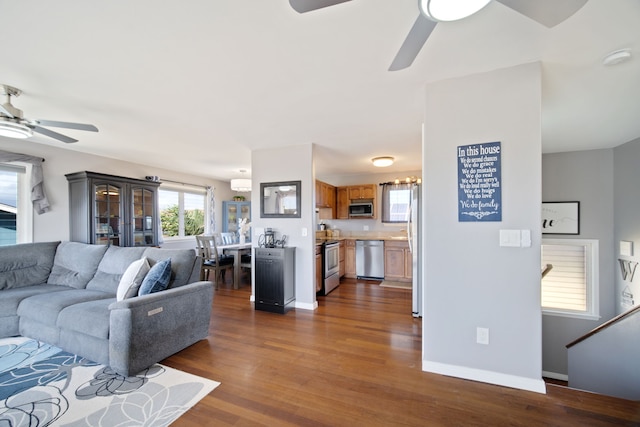 living room with dark wood-type flooring and ceiling fan