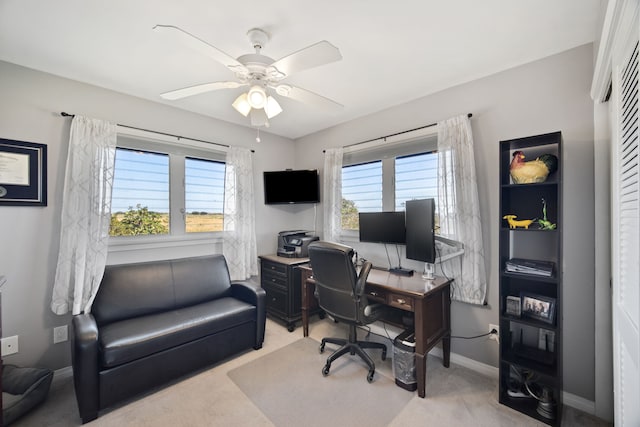 home office featuring plenty of natural light, light colored carpet, and ceiling fan