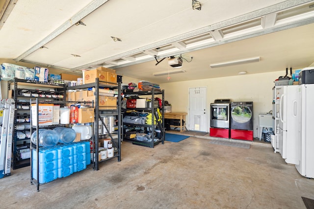 garage featuring a garage door opener, washing machine and dryer, and sink