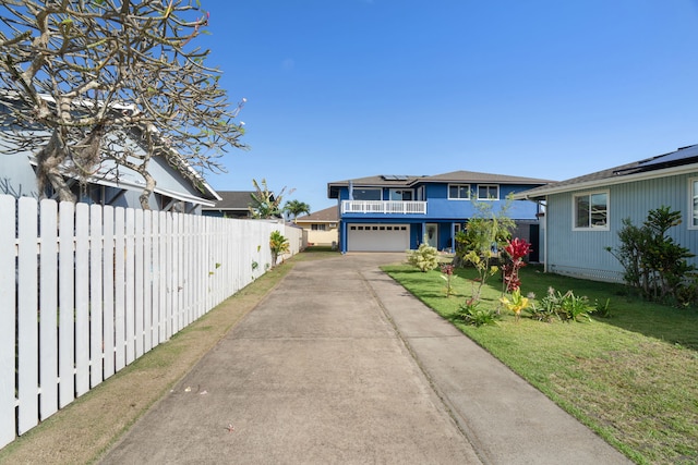 view of front of house with a garage, a front yard, solar panels, and a balcony