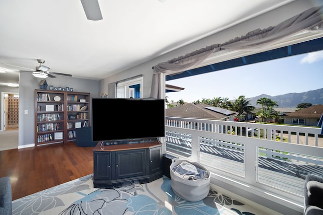 living room featuring ceiling fan and dark hardwood / wood-style floors