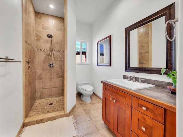 bathroom with toilet, tile patterned flooring, tiled shower, and vanity