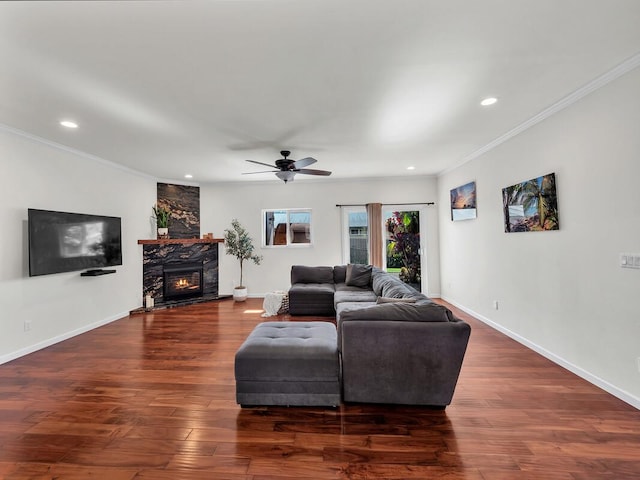 living room with dark hardwood / wood-style flooring, ceiling fan, and ornamental molding