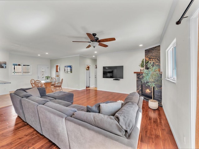 living room featuring hardwood / wood-style flooring, ceiling fan, and crown molding